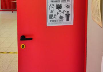 Foto di una porta della prima G in cui è appeso un poster del Linux Winter Day