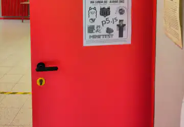 Foto di una porta della prima G in cui è appeso un poster del Linux Winter Day